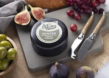 The Hunter - Truffle & Cracked Black Pepper Cheddar cheese displayed on a wooden board with fruits