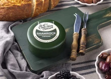 The Shamrock - Irish Whiskey & Stem Ginger Cheddar Cheese on a wooden board with berries and bread