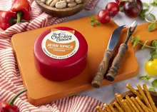 Jerk Spice - Chilli & Garlic Cheddar Cheese on a wooden board with red chilis, tomatoes and knifes