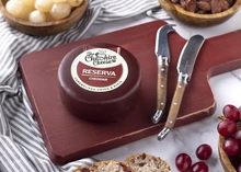 Reserva Caramelised Onion & Rioja Red Wine Cheddar on a wooden board with berries and bread slices