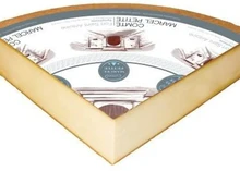 A triangular slice of Comté Symphonie, aged 16-24 months, with a label on top, is set against a white background