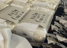 A batch of Bath Soft Cheese with truffle, all wrapped in labeled parchment paper
