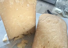 Slices of Beemster XO cheese placed on a butter paper on the table.