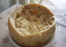 Casu marzu, a controversial Sardinian cheese, showing live insect larvae (maggots) on a white plate on a table