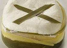 Grassias cheese wrapped in lemongrass showcasing its soft, clay-like texture