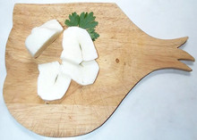 Fresh sliced Halloumi cheese with a whole leaves of mint in the middle of a wooden board.
