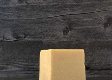 A block of Prairie Breeze Cheddar cheese on a wooden surface