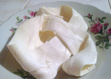 Traditional Mexican Oaxaca cheese, also known as Quesillo, on a decorative white plate