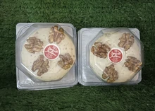 St Julien cheese packets with crunchy walnuts arranged on lush green grass