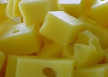 Blocks of Swiss cheese displaying a pale yellow color and distinctive holes ('eyes')