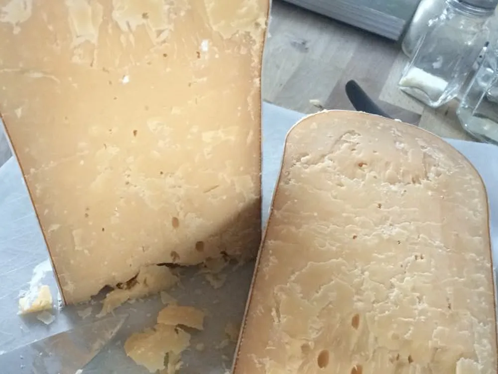 Slices of Beemster XO cheese placed on a butter paper on the table.